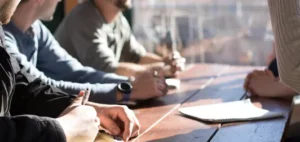 Eine Personengruppe sitzt am Tisch und bereiten sich auf die MPU vor.